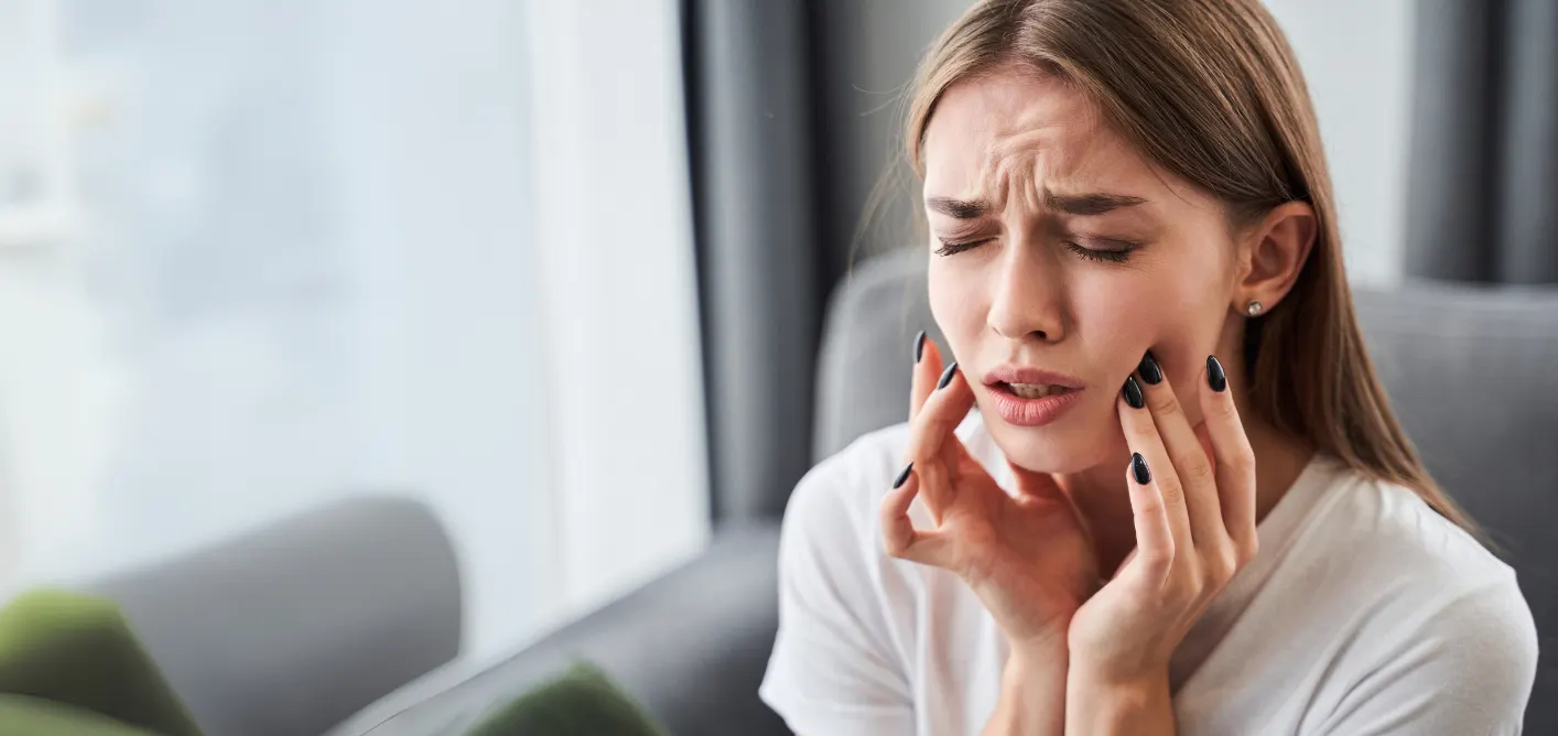 Woman holding her jaw in pain