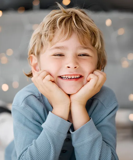 Smiling young boy resting his chin on his hands